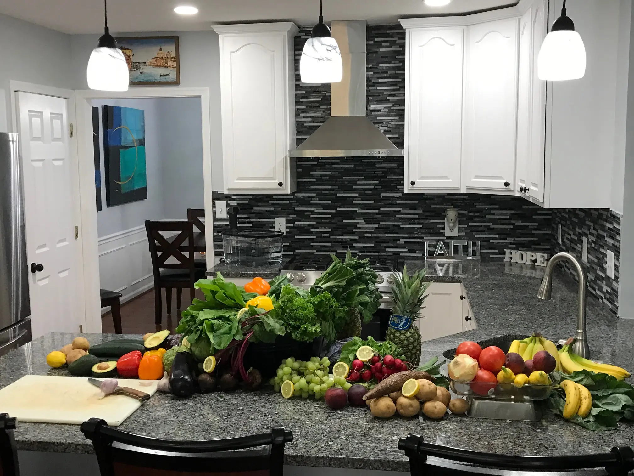 Kitchen counter with assorted fruits and vegetables.