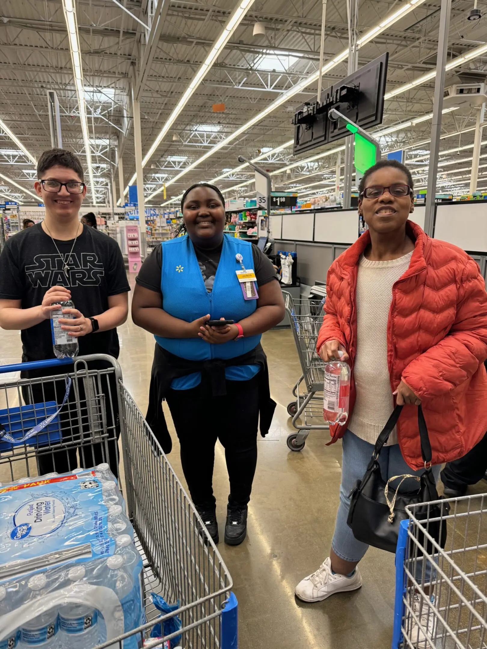 Three people in a store aisle.