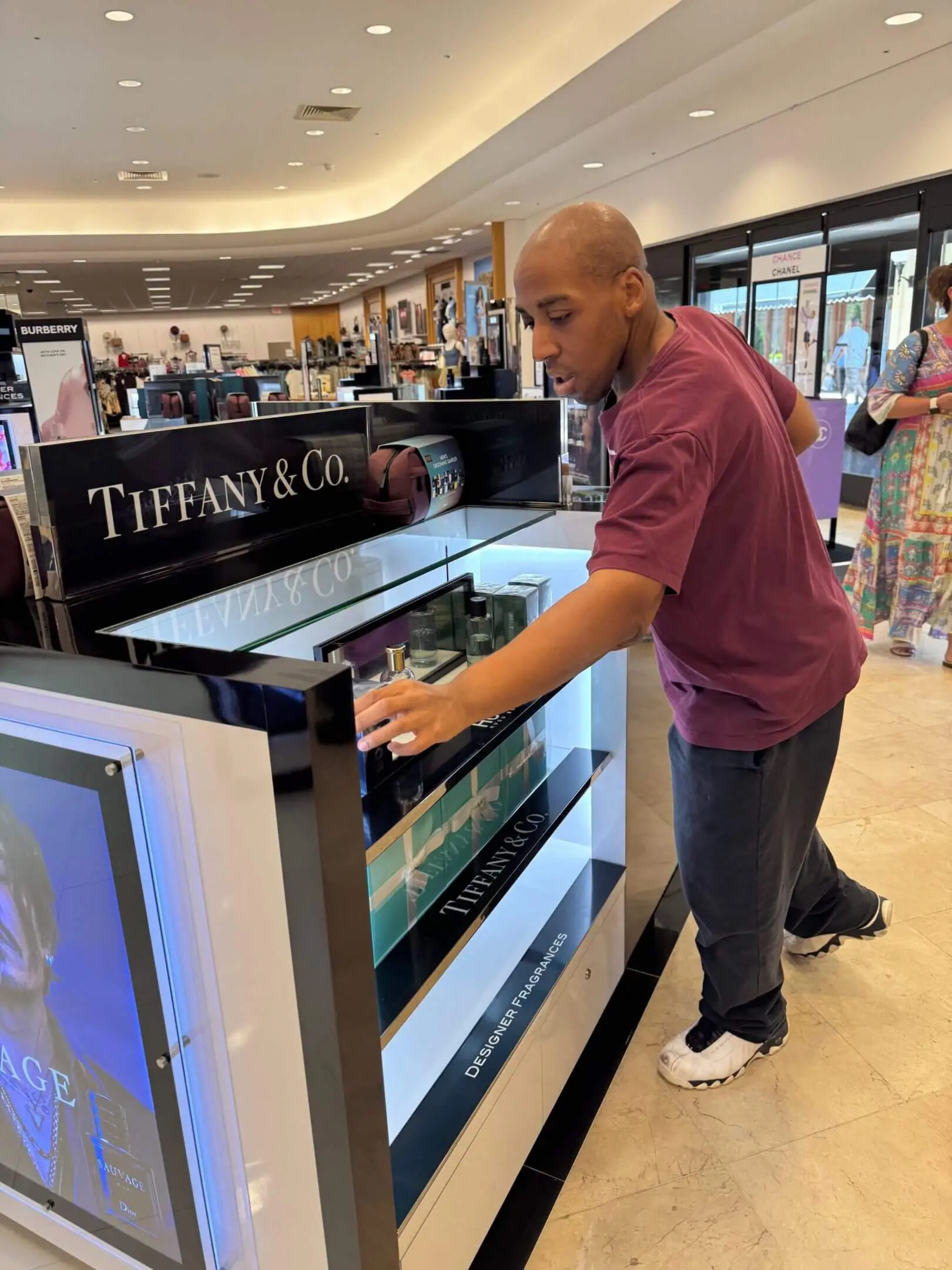 Man looking at jewelry inside a Tiffany & Co. display case.