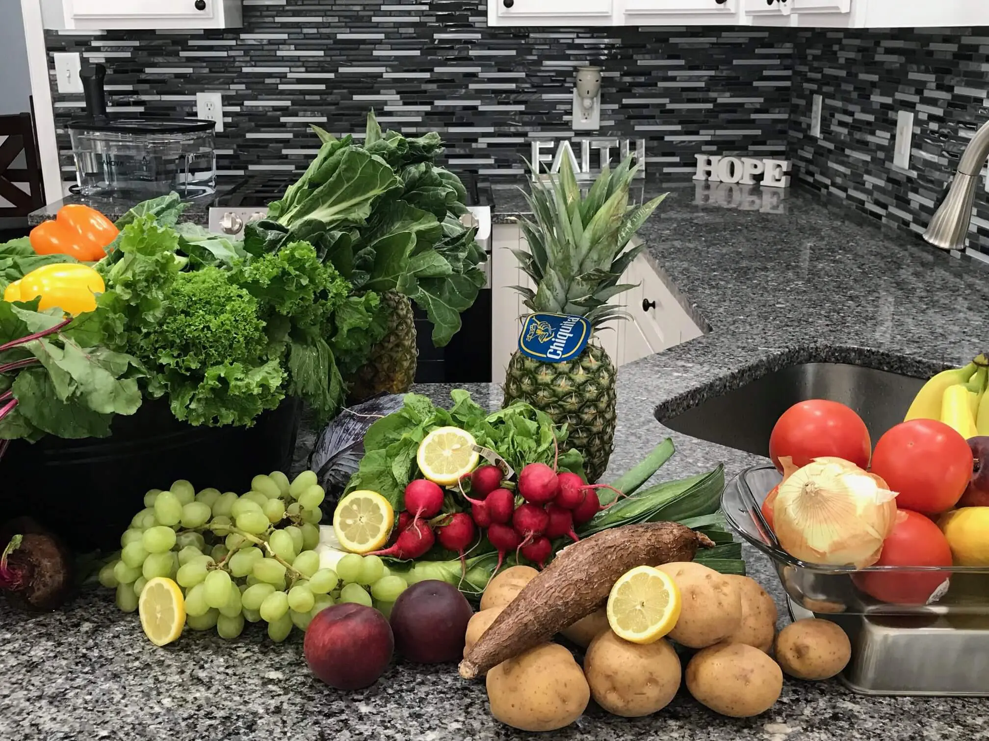 Fresh fruits and vegetables arranged on a kitchen counter.
