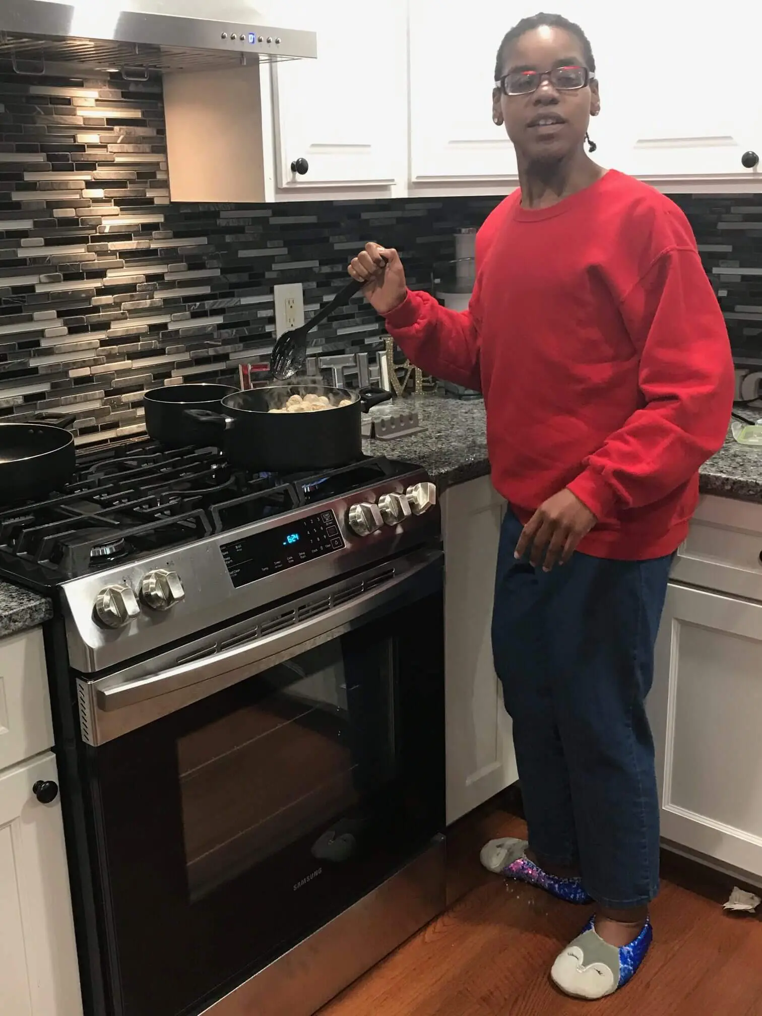 Person cooking on a modern stove in a kitchen.