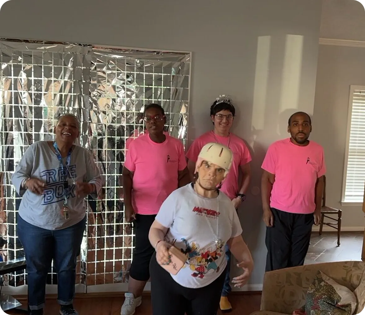 Group of people posing indoors, smiling.