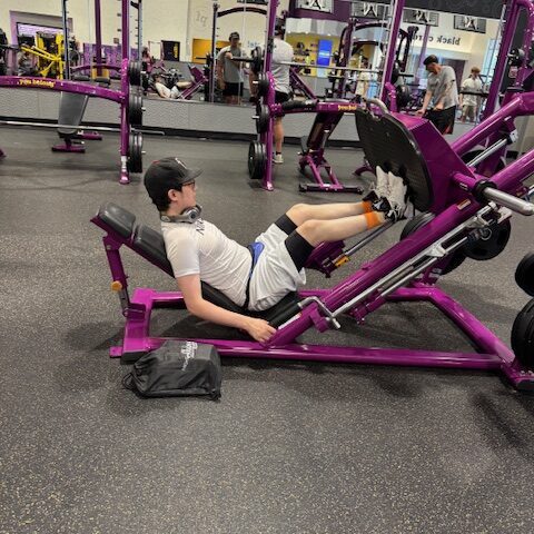 Person using a leg press machine at the gym.