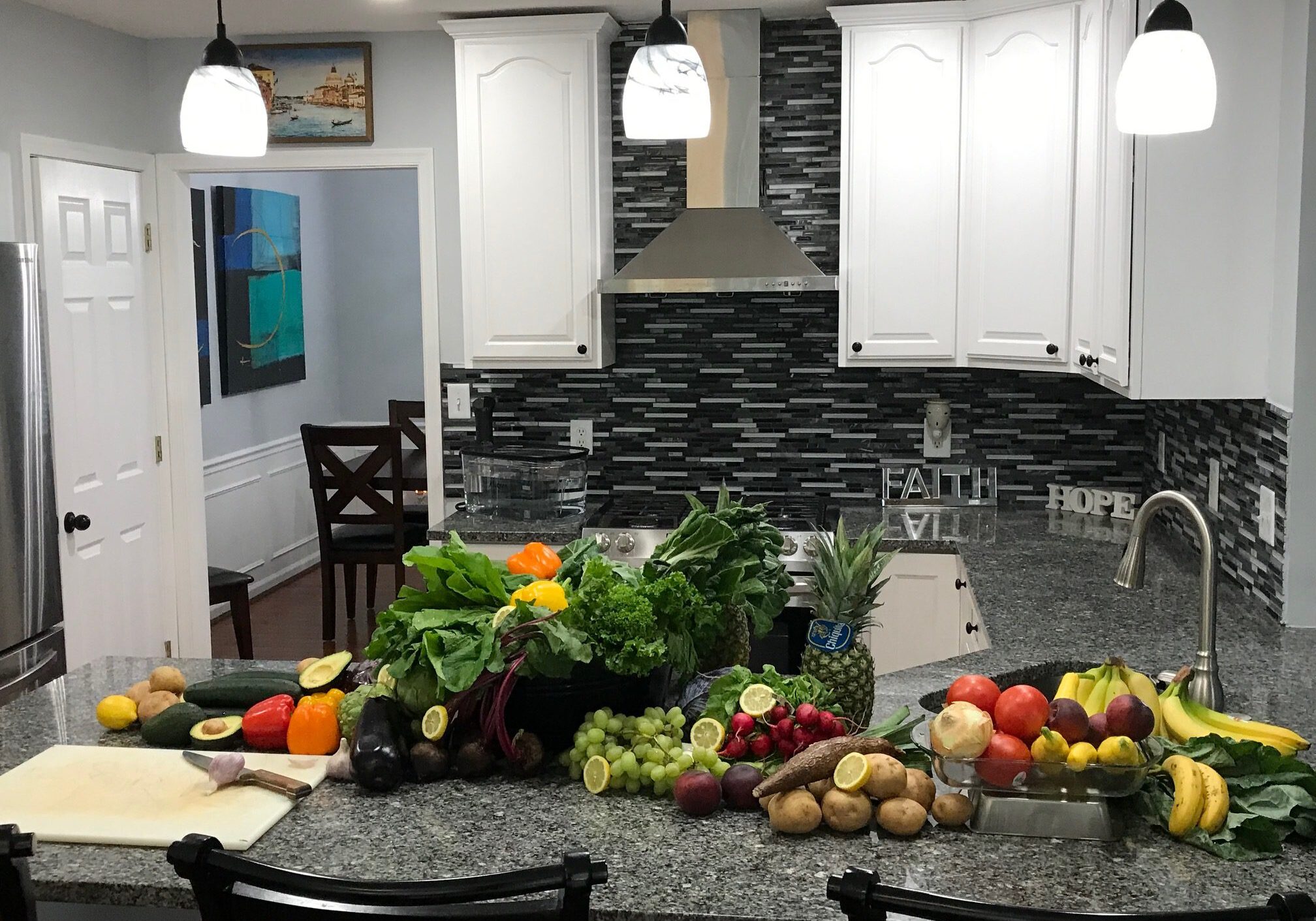 Kitchen counter with assorted fruits and vegetables.