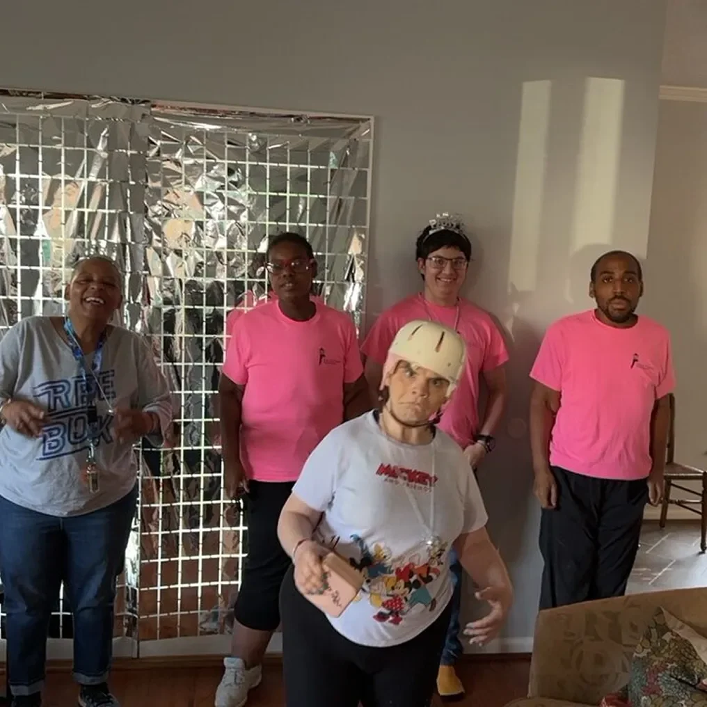 Group of people posing indoors, smiling.